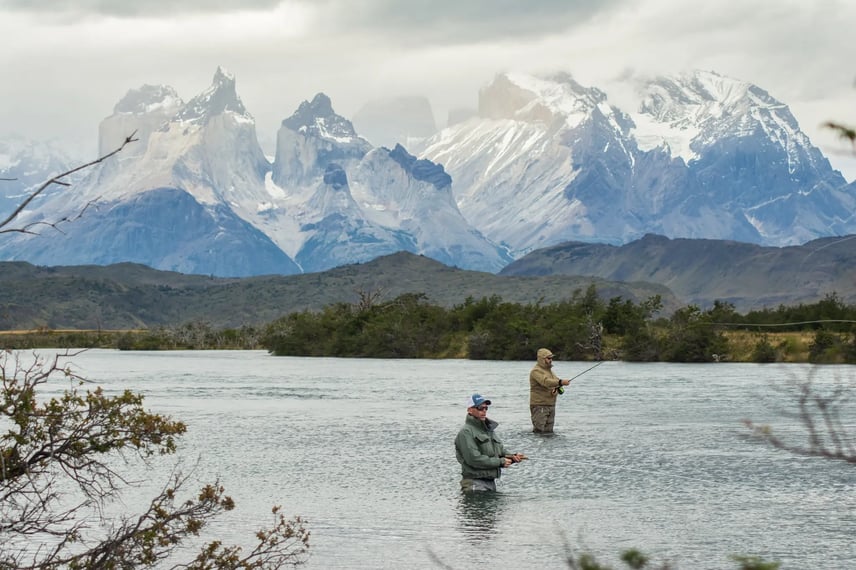 Two anglers standing in a river or lake in Torres del Paine while fly fishing