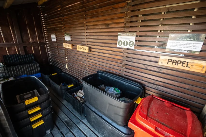 EcoCamp Patagonia’s on-site recycling station with labeled bins for sorting paper, cardboard, cans, and plastics as part of its waste management system.