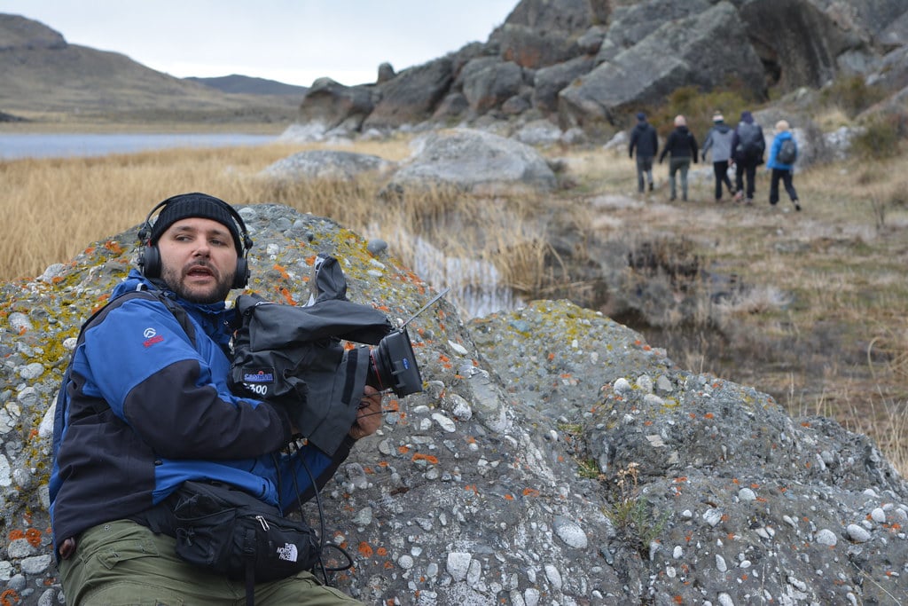 Johnny, the camera operator, is using a rock for a stable shooting.